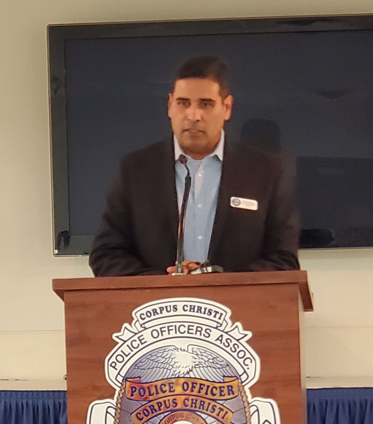 Gil Hernandez speaking at the Corpus Christi Police Officers Association podium